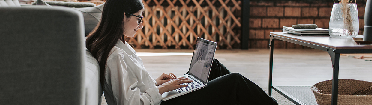 Young woman in living room on computer.