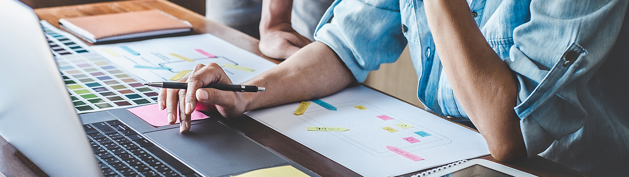 abstract zoomed in view of two employees working on a new website wireframe and color swatches