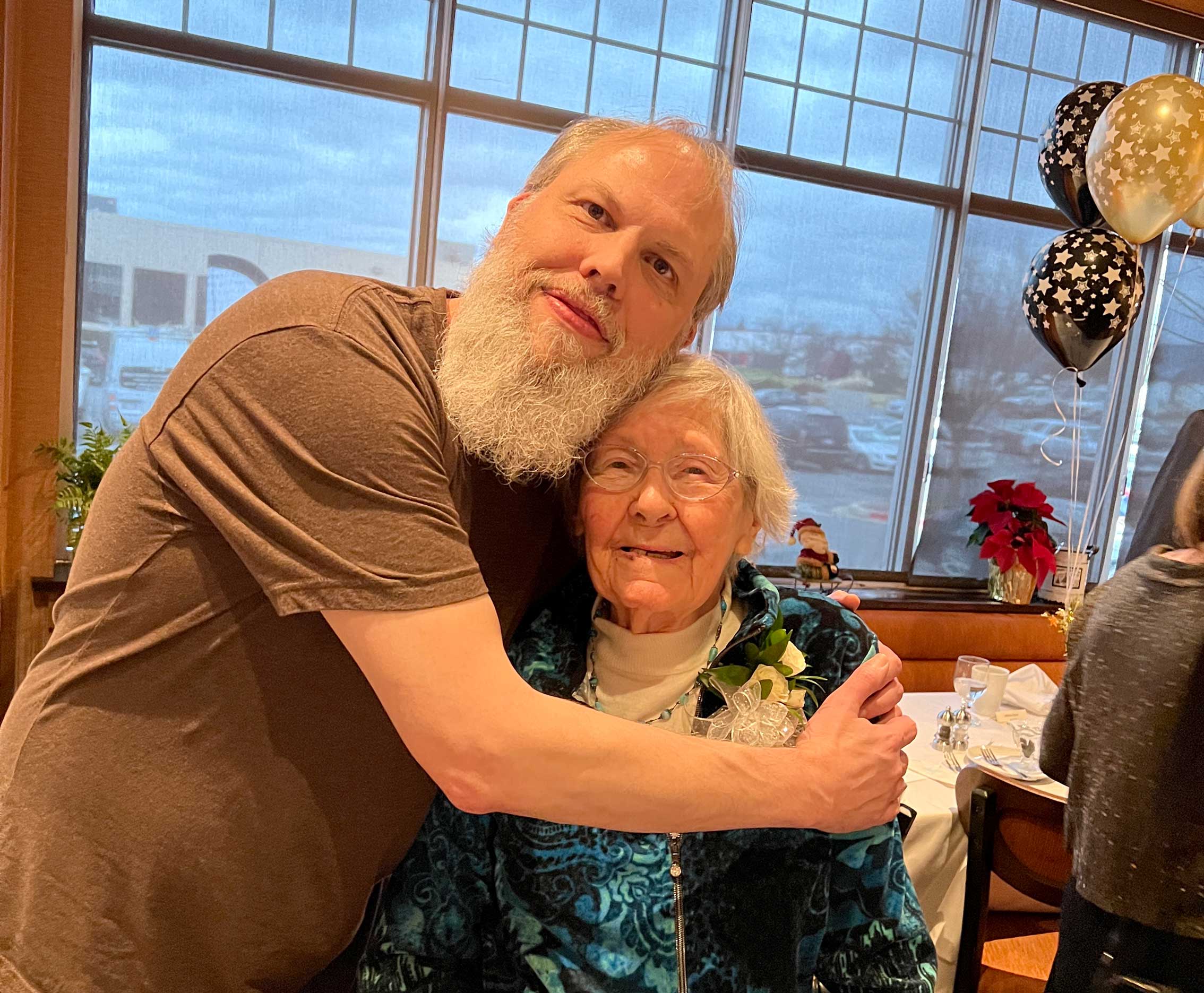 Scott Perry smiling and hugging is grandmother at a birthday party