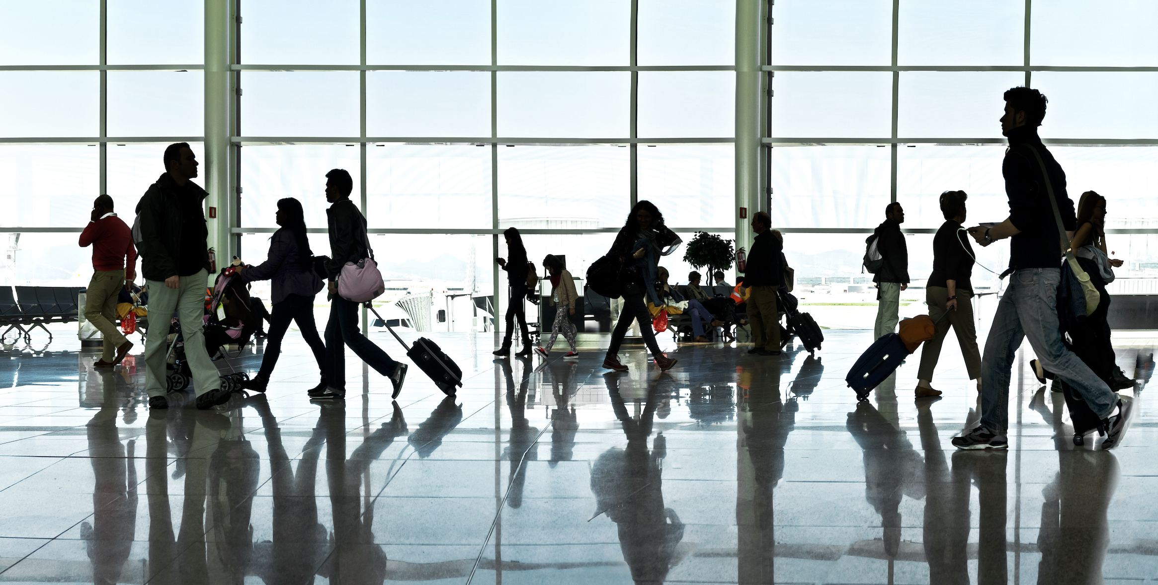 zoomed out shot of people walking in an airport